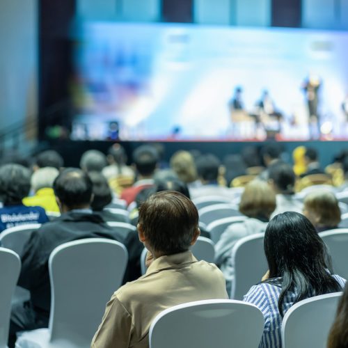 Rear view of Audience listening Speakers on the stage in the conference hall or seminar meeting, business and education about investment concept